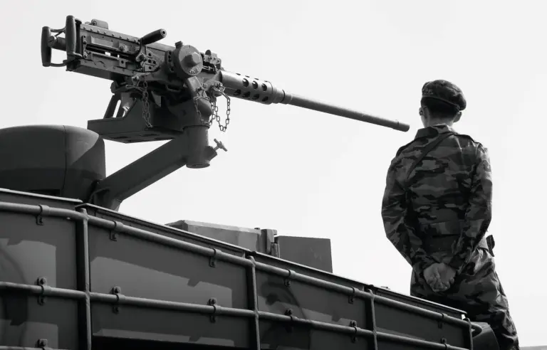 Ein Soldat in Uniform steht auf einem Panzer, hinter ihm ist ein Maschinengewehr zu sehen. Credit: Noh Suntag