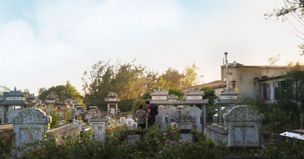 Zwei junge Menschen statten einen Besuch auf einem Friedhof ab